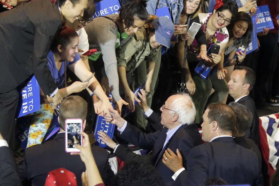 Democratic presidential candidate Sen. Bernie Sanders, I-Vt., bottom, shakes hands with supporters at a rally held at the Anaheim Convention Center, Tuesday, May 24, 2016, in Anaheim, Calif.