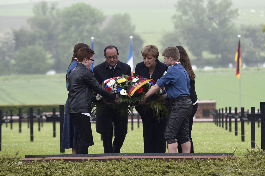French President Fran?ois Hollande, left, and German Chancellor Angela Merkel lay a wreath Sunday at a German cemetery in Consenvoye, France during a remembrance ceremony to mark the centenary of the battle of Verdun. Hollande and Merkel are marking 100 years since the 10-month Battle of Verdun, which killed 163,000 French and 143,000 German soldiers and wounded hundreds of thousands.