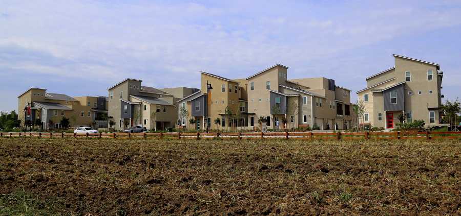 Townhomes at The Cannery sit beside the plowed field of the small, urban farm that is a centerpiece of the community in Davis, Calif. Housing developments incorporating farms, known as agrihoods, are a new niche in the market.