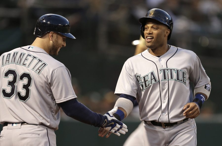 Seattle Mariners&#039; Robinson Cano, right, is congratulated by Chris Iannetta, left, after scoring against the Oakland Athletics in the fourth inning of a baseball game Monday, May 2, 2016, in Oakland, Calif.