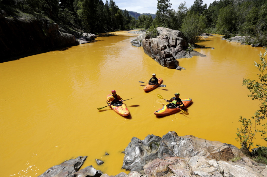 People kayak in the Animas River near Durango, Colo., on Aug. 6, 2015, in water colored from a mine waste spill.