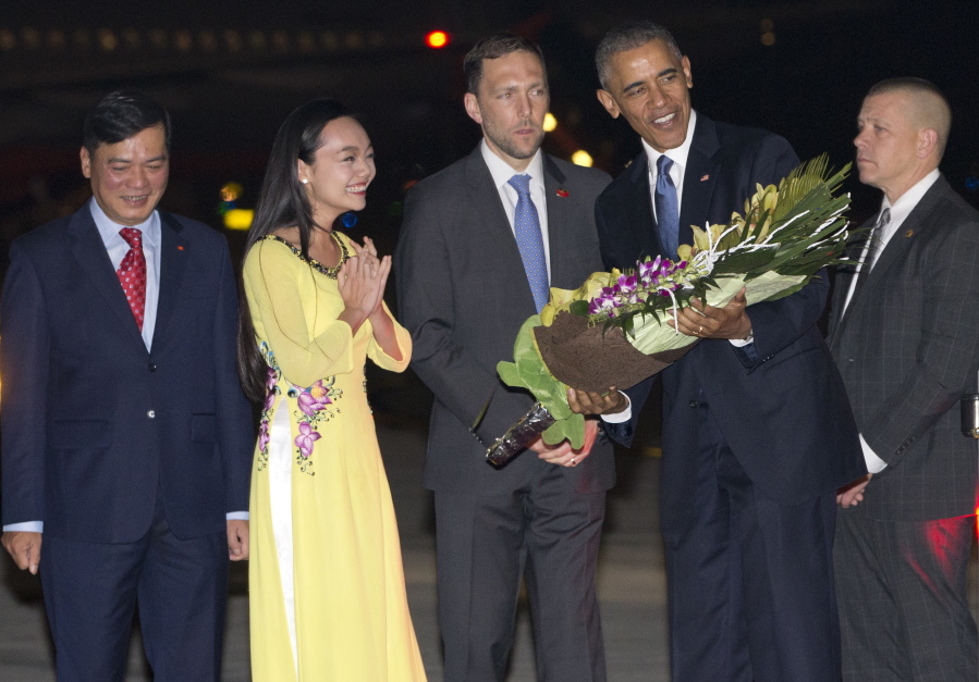 President Barack Obama is given flowers by Linh Tran, a ceremonial flower girl, as he arrives Sunday at Noi Bai International Airport in Hanoi, Vietnam. The president is on a weeklong trip to Asia as part of his effort to pay more attention to the region and boost economic and security cooperation.