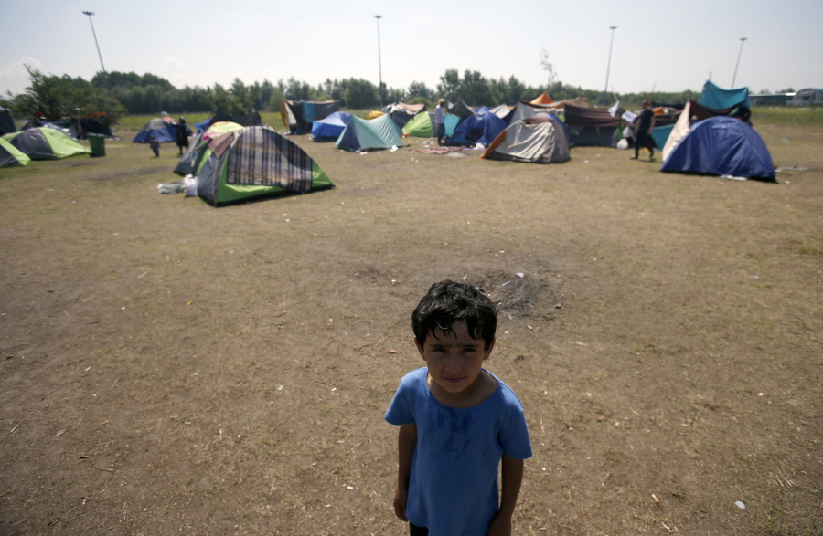 A boy stands Friday in the makeshift refugee camp near the Horgos border crossing into Hungary, near Horgos, Serbia. Nearly 400,000 refugees passed through Hungary last year on their way to richer EU destinations. The flow was slowed greatly by Hungary&#039;s construction of razor-wire fences on its borders with Serbia and Croatia.