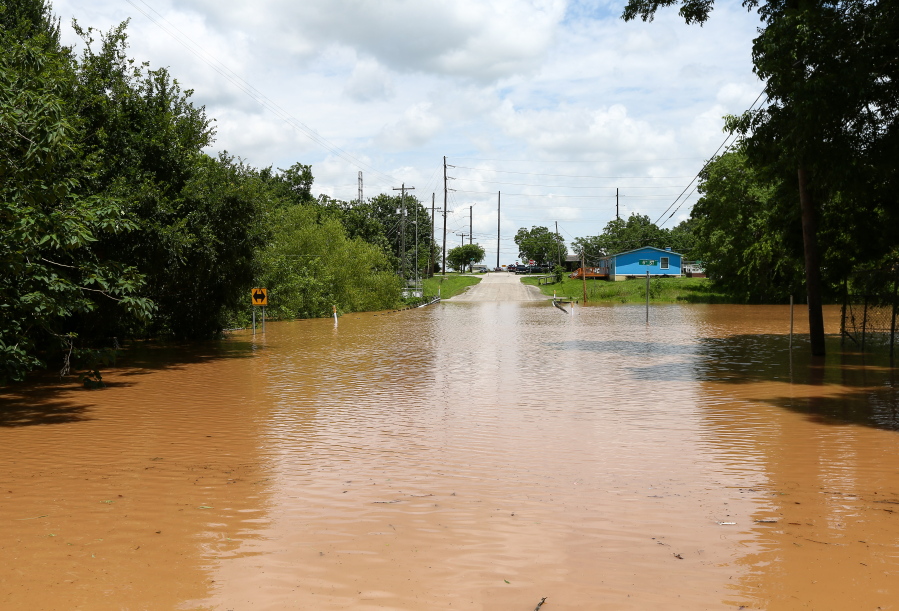 Sixth Street is impassible due to rising flood waters from the Brazos River on Sunday in Rosenberg, Texas.