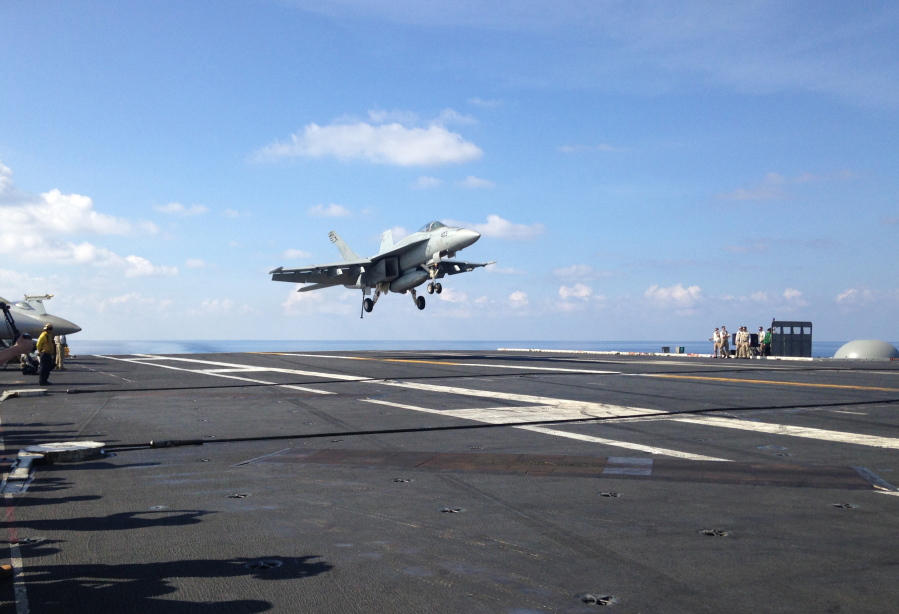 An FA-18 jet fighter lands on the USS John C. Stennis aircraft carrier in the South China Sea while U.S. Defense Secretary Ash Carter visited the aircraft carrier during a trip to the region.  (AP Photo/Lolita C.