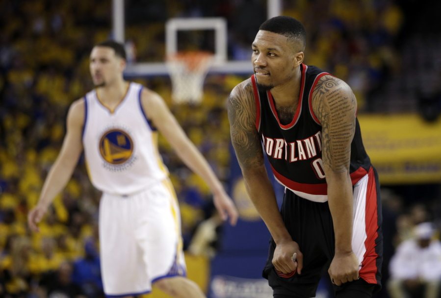 Portland Trail Blazers&#039; Damian Lillard (0) pauses during a timeout next to Golden State Warriors&#039; Klay Thompson, left, during the second half in Game 1 of a second-round NBA basketball playoff series, Sunday, May 1, 2016, in Oakland, Calif. Golden State won 118-106.