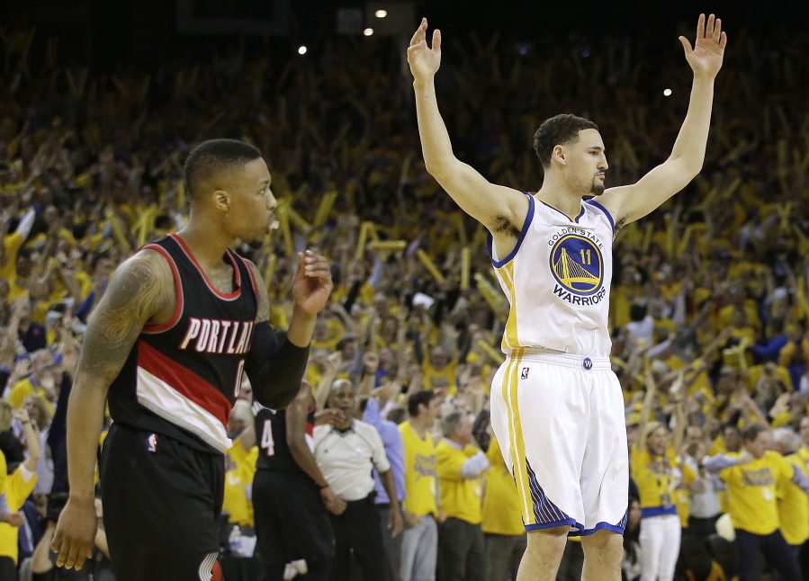 Golden State Warriors guard Klay Thompson (11) reacts after scoring next to Portland Trail Blazers guard Damian Lillard during the second half in Game 2 of a second-round NBA basketball playoff series in Oakland, Calif., Tuesday, May 3, 2016.