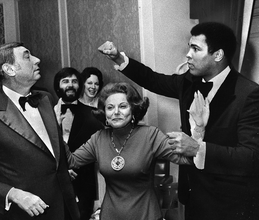 At a dinner on Nov. 11, 1977, in Chicago, Muhammad Ali takes a playful poke at sportscaster Howard Cosell, left, with advice columnist Ann Landers appealing for calm. Ali died on June 3 at 74.