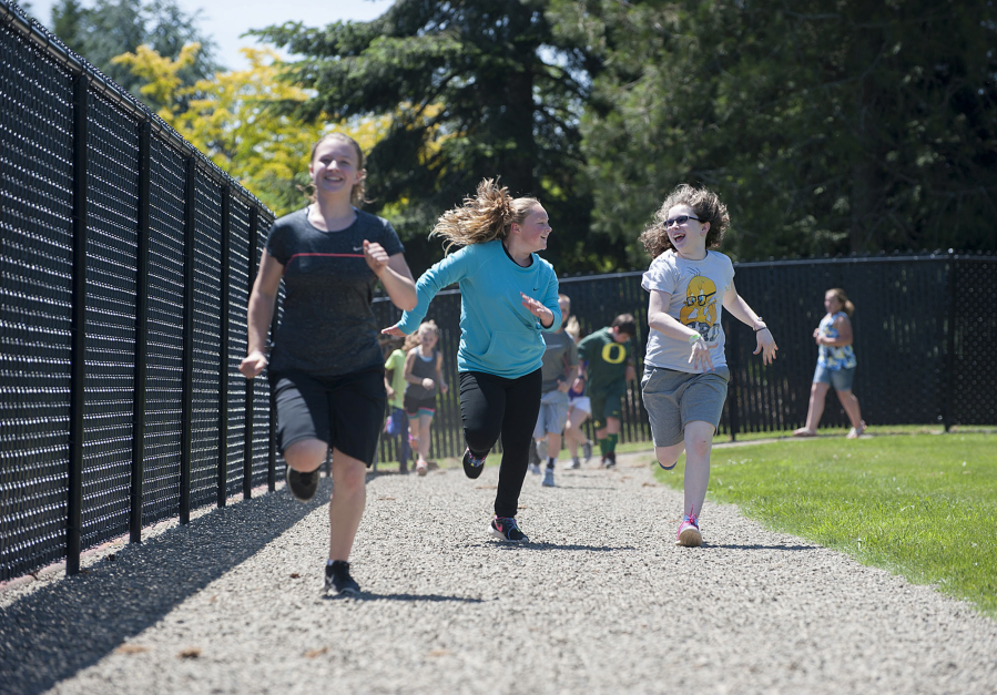 Fifth-graders Sara Watson, from left, Taylor Allsup and Kaylen Duncan keep pace as they jog laps around Hockinson Heights Elementary School&#039;s new track last week. Donations from community members and from Karvonen Sand and Gravel made the newly remodeled track possible.