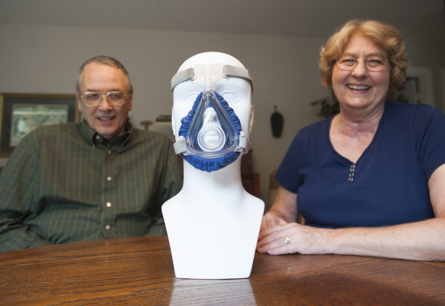 Vicki and Norman Paulk on Wednesday demonstrate the CPAP mask cover they designed at their home in Camas. Norman, who suffers from sleep apnea, invented a soft fabric guard to help make wearing the oxygen mask for an extend period of time more comfortable.
