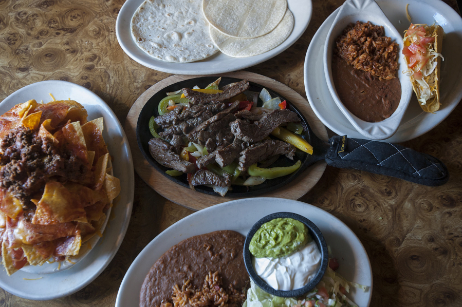 Nachos with taco beef, from left, are seen with steak fajitas as well as a crispy shell chicken taco with rice and beans at The Original Taco House in Vancouver.