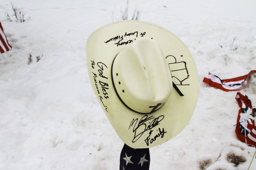 A signed hat is part of a memorial set up to mark the place Robert LaVoy Finicum died.