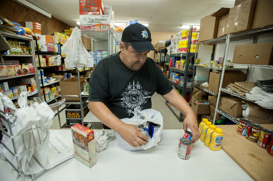 Volunteer Steve Goodin sorts through donated food Thursday evening at the new location of Martha&#039;s Pantry in Vancouver Heights United Methodist Church.