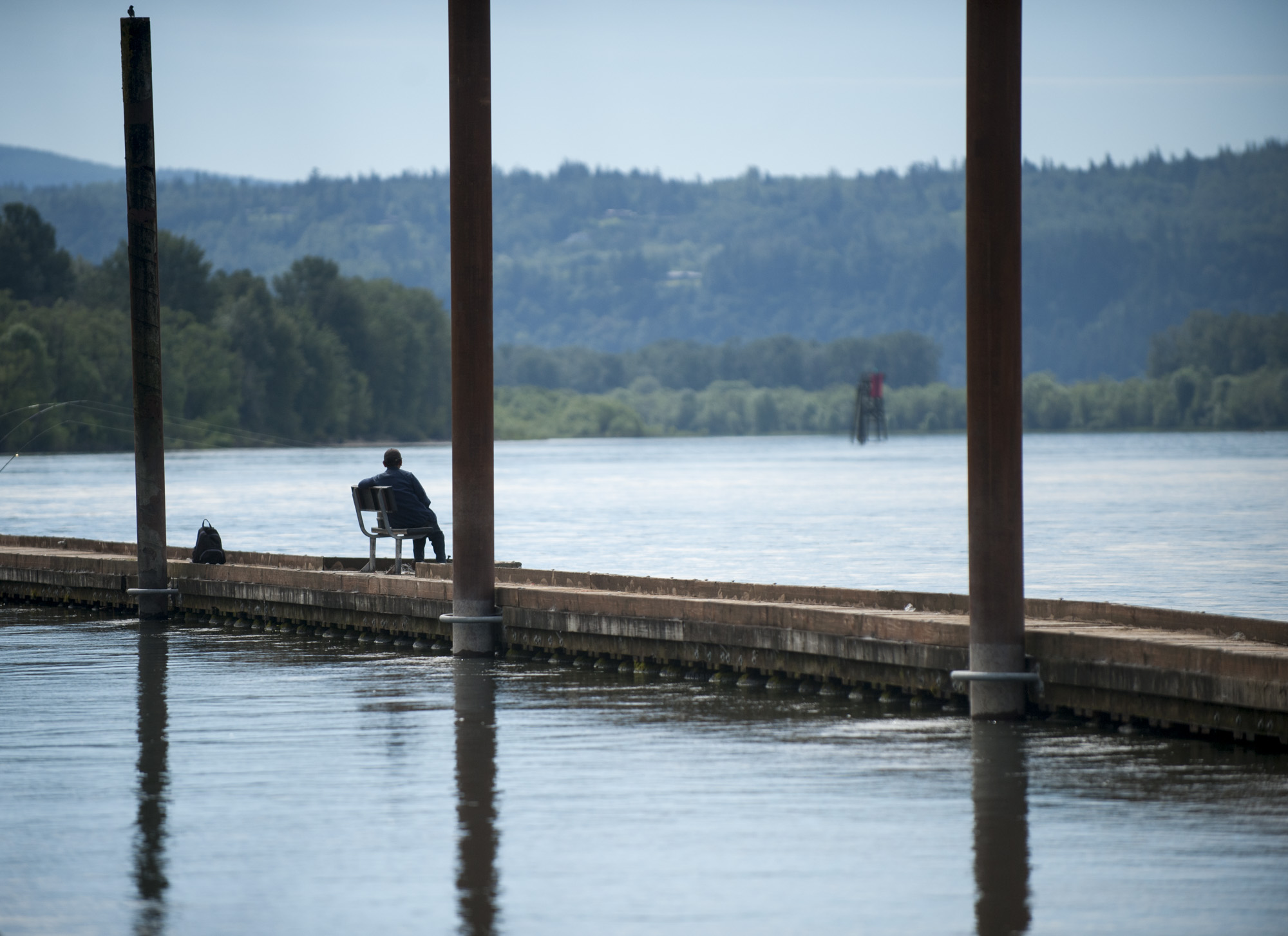 A visitor enjoys a cool breeze on a jetty over the Columbia River in Washougal on Friday.
