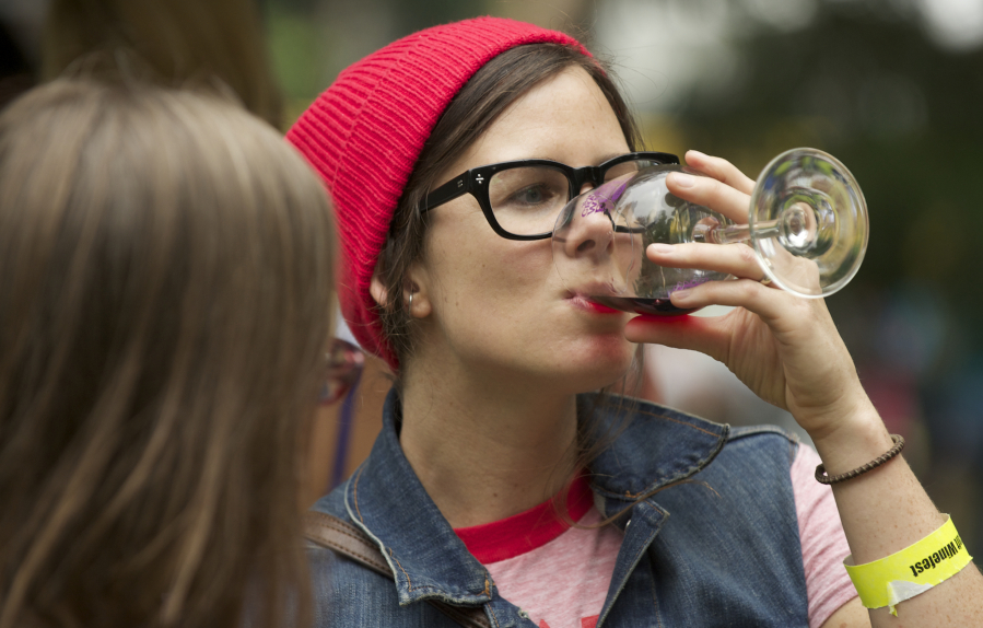 Vancouver native Mary Andersen, now living in Portland, samples wine from one of the 20 wineries participating in the Craft Beer &amp; Winefest at Esther Short Park in 2013.