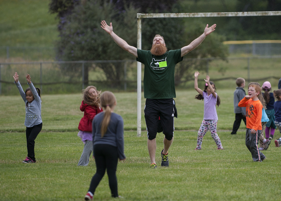 Timbers defender Nat Borchers joins students as they celebrate a goal while playing soccer Thursday afternoon, at Burton Elementary School.