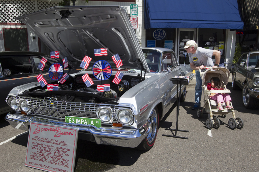 A visitor looks at Donna Habben&#039;s 1963 Chevy Impala SS which is on display at the 2014 Camas Car Show.