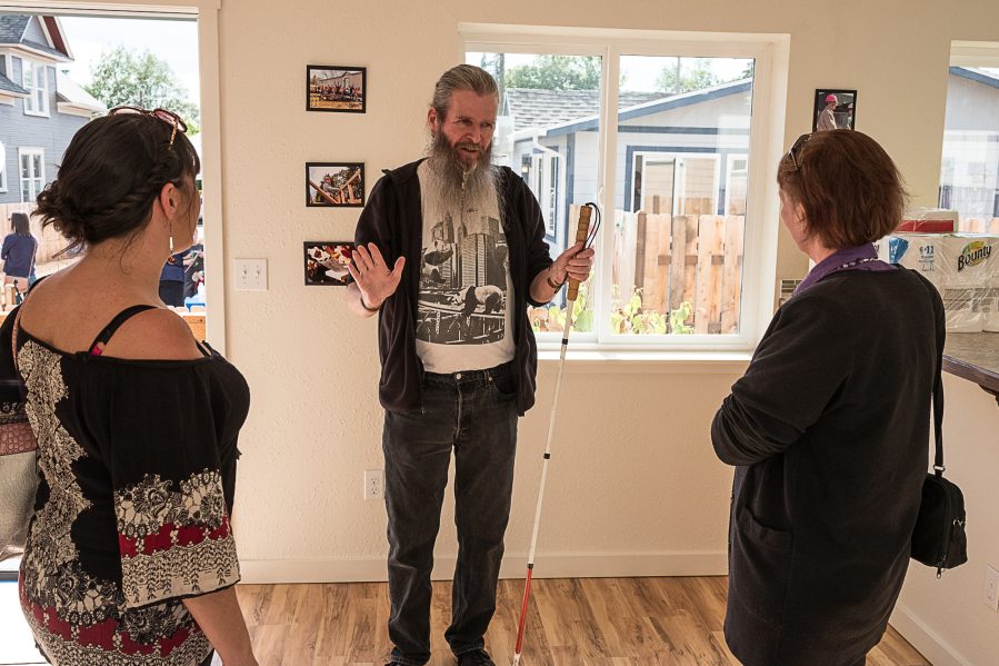 Ken Garringer, center, talks to visitors Friday in his new home, provided by Evergreen Habitat for Humanity with help from Evergreen district high school students.
