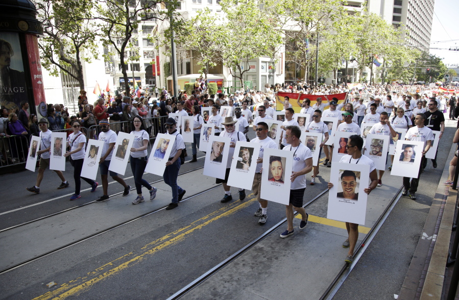 Marchers hold pictures of victims of the Orlando nightclub shooting during the San Francisco Gay Pride parade Sunday in San Francisco.
