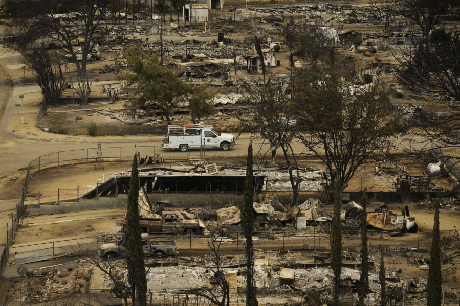 A pickup truck passes by the remains of mobile homes devastated by a wildfire, Saturday, June 25, 2016, in South Lake, Calif.  Gov. Jerry Brown declared a state of emergency, freeing up money and resources to fight the fire and to clean up in the aftermath. The Federal Emergency Management Agency also authorized the use of funds for firefighting efforts. (AP Photo/Jae C. Hong) (JAE C.