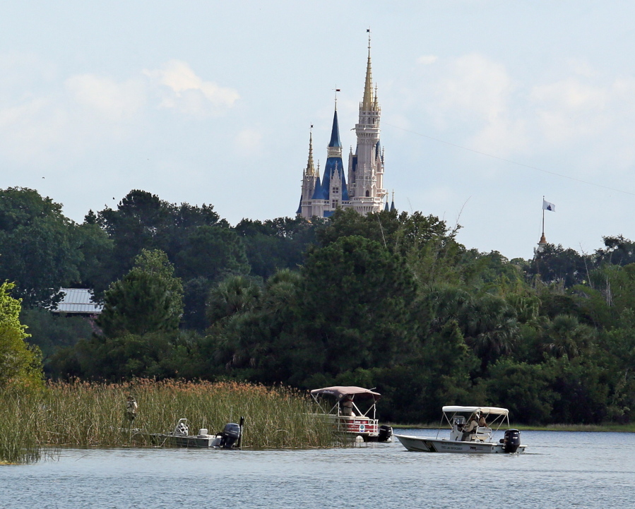 In the shadow of the Magic Kingdom, authorities search on June 15 for the body of a boy who was dragged away by an alligator at Grand Floridian Resort at Disney World in Lake Buena Vista, Fla.