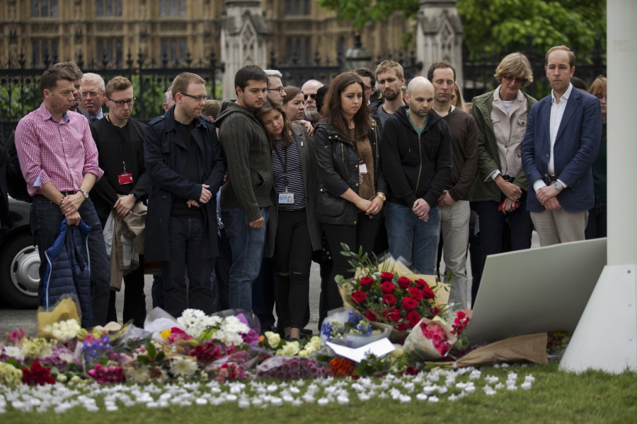 Staff from Britain&#039;s Labour Party stand together after placing floral tributes for their colleague Jo Cox on Friday outside the House of Parliament in London.