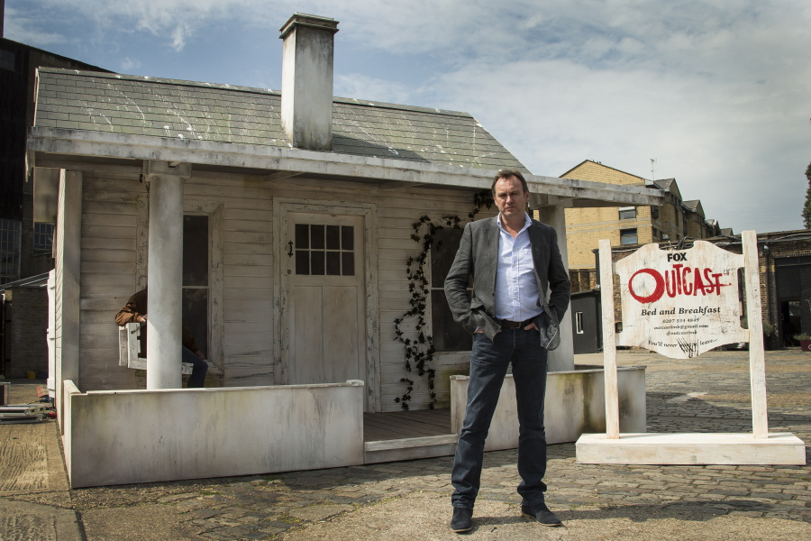 Philip Glenister, who plays The Rev. Anderson in &quot;Outcast,&quot; stands in front of the &quot;Scare B&amp;B,&quot; a possessed pop-up house in central London.