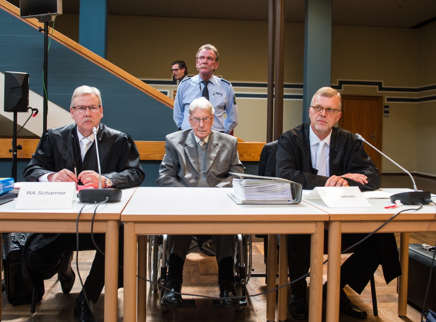94-year-old former SS sergeant Reinhold Hanning who served as a guard at Auschwitz sits between his lawyers Andreas Scharmer, left, and Johannes Salmen, right,  in the courtroom in Detmold on Friday. He has been found guilty of more than 170,000 counts of accessory to murder on allegations he helped the Nazi death camp kill 1.1 million Jews and others. Henning was sentenced to five years in prison.