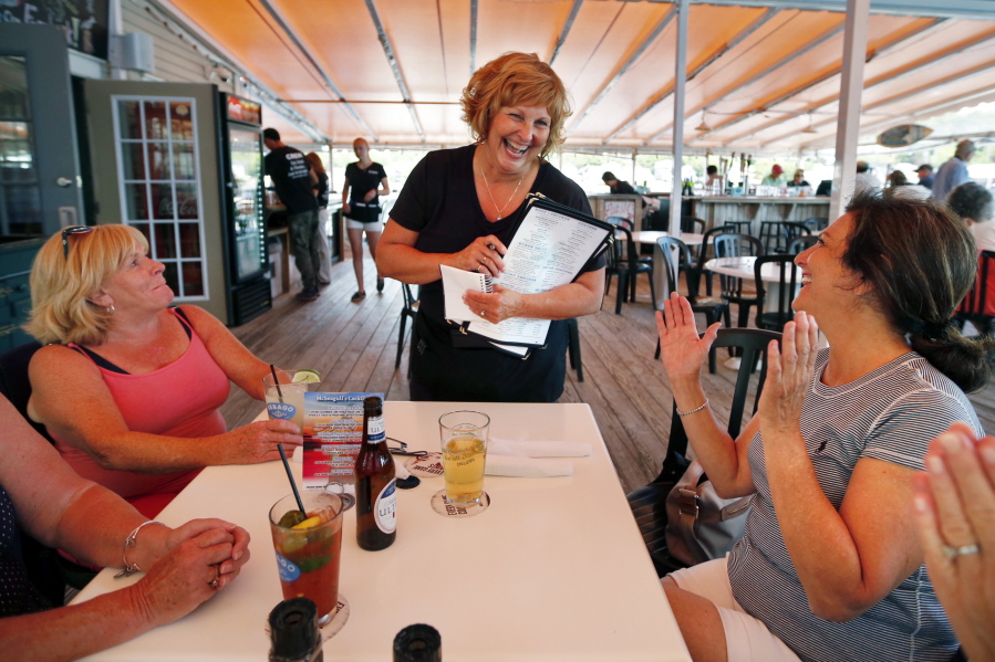 Ann LePage chats with diners after taking their order at McSeagull&#039;s restaurant, Thursday, June 23, 2016, in Boothbay Harbor. The wife of America&#039;s lowest paid governor has taken on a summer waitressing job near her and husband&#039;s Boothbay home,  and she&#039;s saving up for a car. (AP Photo/Robert F.