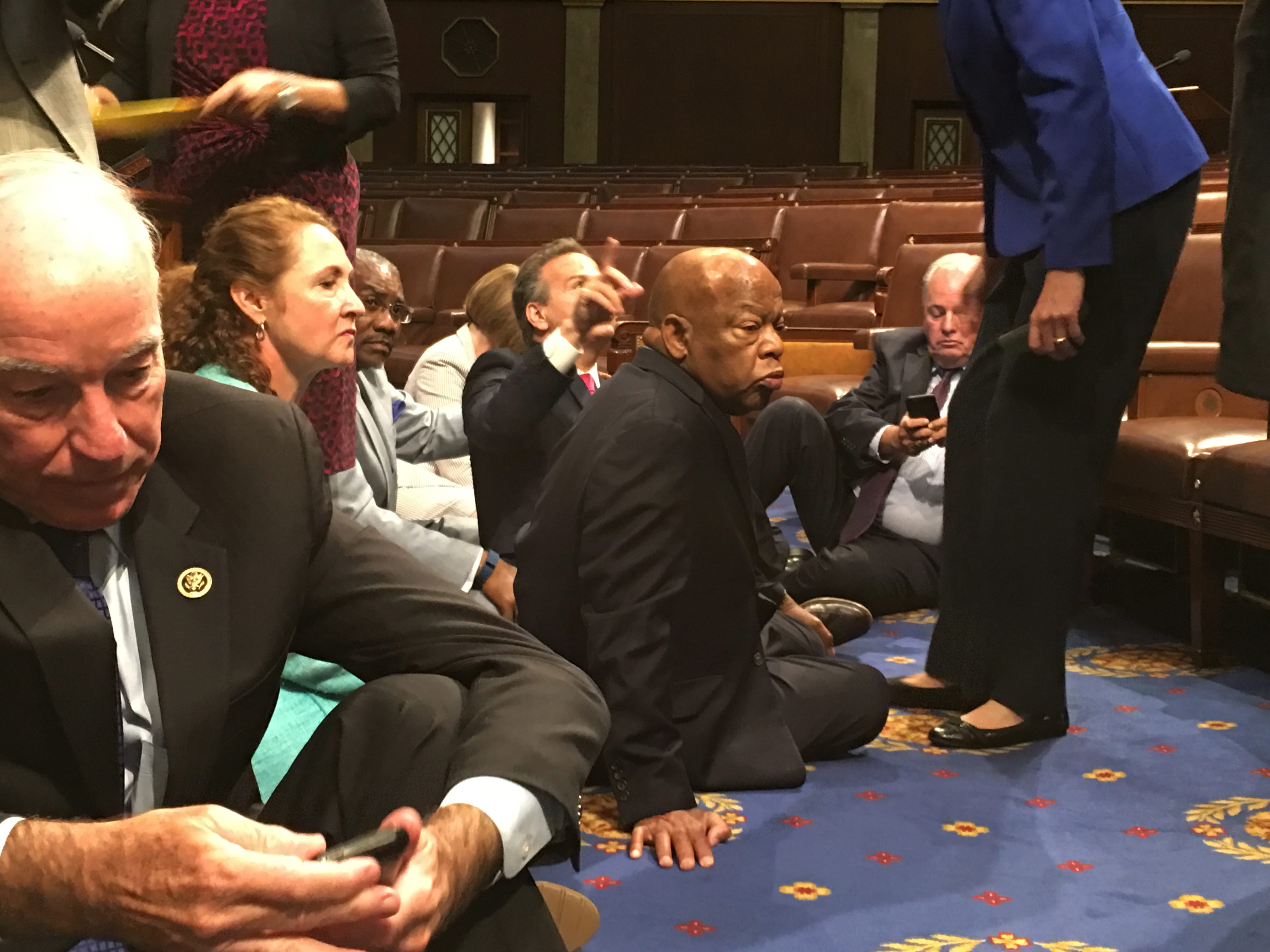 This photo provided by Rep. John Yarmuth, D-Ky., shows Democrat members of Congress, including Rep. John Lewis, D-Ga., center, and Rep. Joe Courtney, D-Conn., left, participate in sit-down protest seeking a a vote on gun control measures, Wednesday, June 22, 2016, on the floor of the House on Capitol Hill in Washington. (Rep.