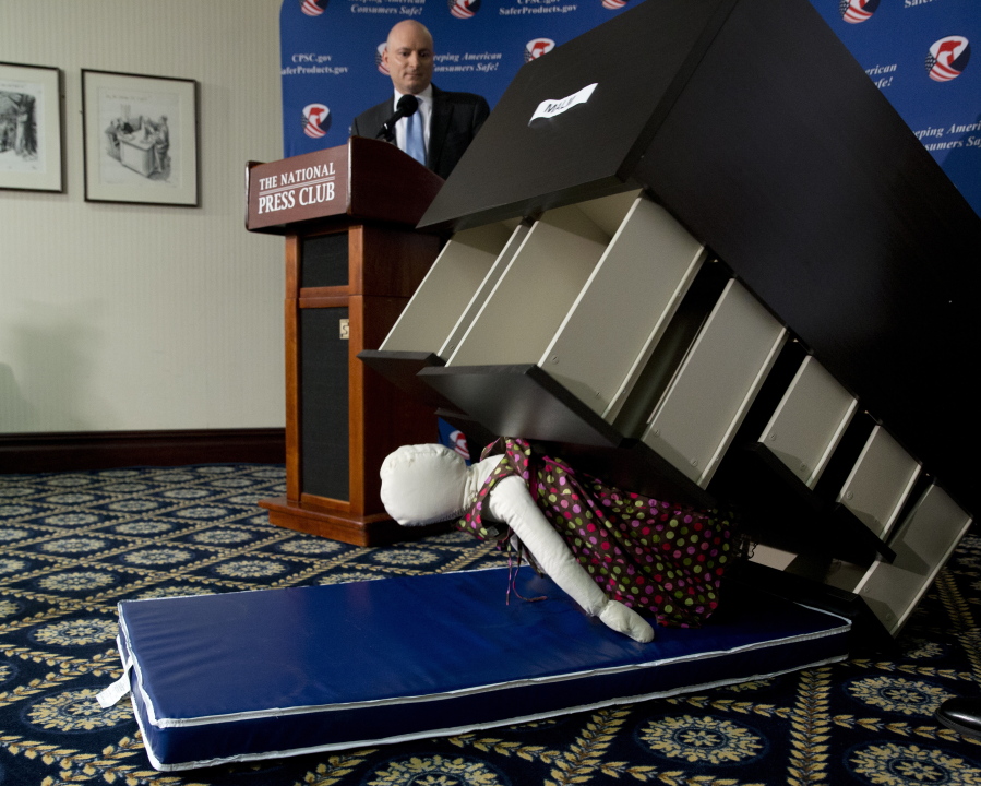 Consumer Product Safety Commission Chairman Elliot Kaye watches a demonstration of how an Ikea dresser can tip and fall on a child during a news conference at the National Press Club in Washington on Tuesday. Ikea is recalling 29 million chests and dressers after six children were killed when the furniture toppled over and fell on them.