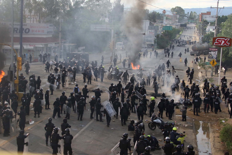 Riot police gather and regroup as they battle all day with protesting teachers who were blocking a federal highway in the state of Oaxaca, near the town of Nochixtlan, Mexico, Sunday, June 19, 2016. The teachers are protesting against plans to overhaul the country&#039;s education system which include federally mandated teacher evaluations.