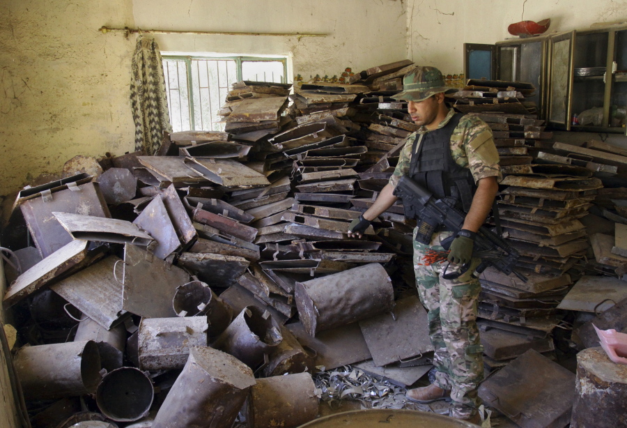 An Iraqi soldier on Monday inspects a workshop on the southern outskirts of Fallujah, Iraq. Militants used the workshop belonging to the Islamic State group to manufacture explosives.