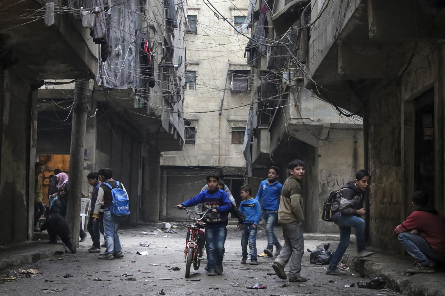 School boys play in a street in February in Aleppo, Syria. After four years of grinding battles, Aleppo&#039;s divided residents face a common fear as the prospect of a total siege looms.