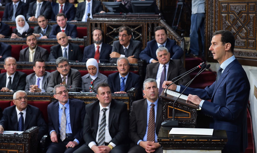 Syrian President Bashar Assad, right, addresses a speech to the newly-elected parliament at the parliament building, in Damascus, Syria, Tuesday. Assad has vowed to liberate every inch of the country the way government forces captured the historic town of Palmyra from the Islamic State group.