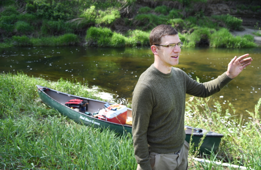 In this April 28, 2016 photo, Department of Ecology water quality modeler Tighe Stuart, who has spent several days paddling a canoe, towing a testing probe, down Hangman Creek, as he prepares to cover the last few miles of water quality testing on the creek, speaks in Spokane, Wash. Stuart and another tester are recording comprehensive water quality measurements and and stream depth measurements which will be used in models that officials will use to create a water quality plan for the creek, a major tributary of the Spokane River.
