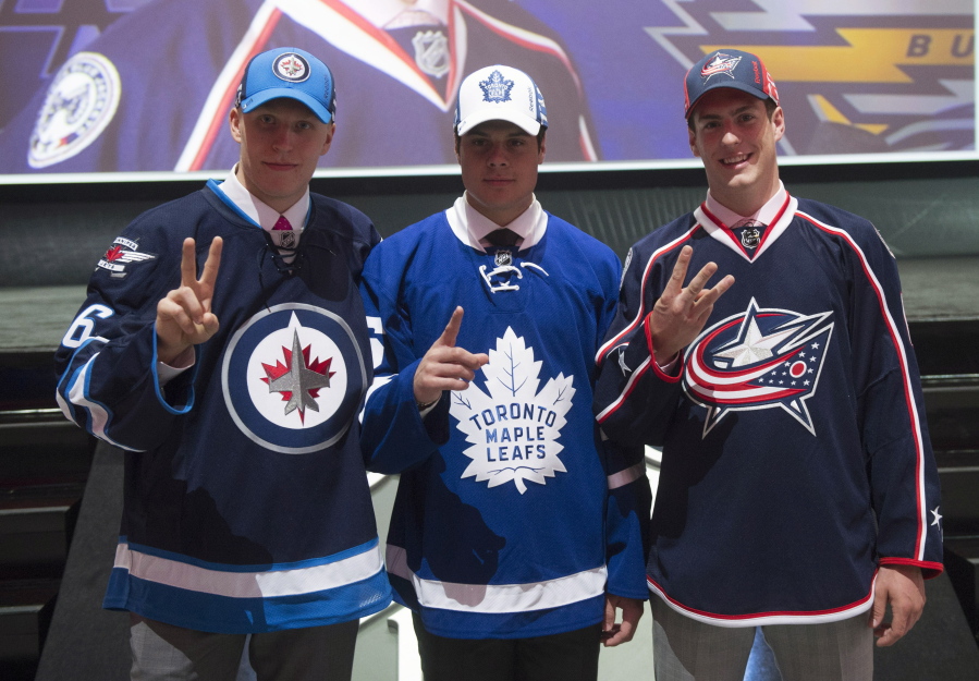 The NHL top three draft picks, Patrik Laine, Winnipeg Jets; Auston Matthews, Toronto Maple Leafs; and Pierre-Luc Dubois, Columbus Blue Jackets, pose for a photo at the NHL hockey draft, Friday, June 24, 2016, in Buffalo, N.Y.