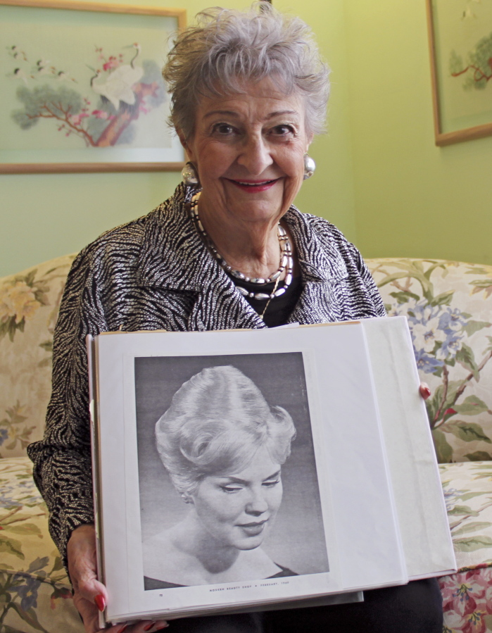 Retired hairstylist Margaret Vinci Heldt, poses for a photo in 2011 at her apartment in Elmhurst, Ill., with a photo of a model with a &quot;beehive&quot; hairdo from the February 1960 edition of Modern Beauty Shop magazine. Heldt, who became a hairstyling industry celebrity after she created the famous beehive hairdo in 1960, has died at age 98. Ahlgrim Funeral Home said Monday that Heldt died Friday at a senior living community.
