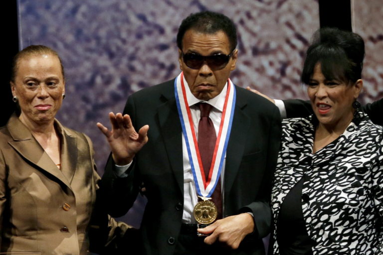 Retired boxing champion Muhammad Ali, center, waves alongside his wife Lonnie Ali, left, and his sister-in-law Marilyn Williams, right, after receiving the Liberty Medal during a ceremony at the National Constitution Center in Philadelphia on Sept. 13, 2012.
