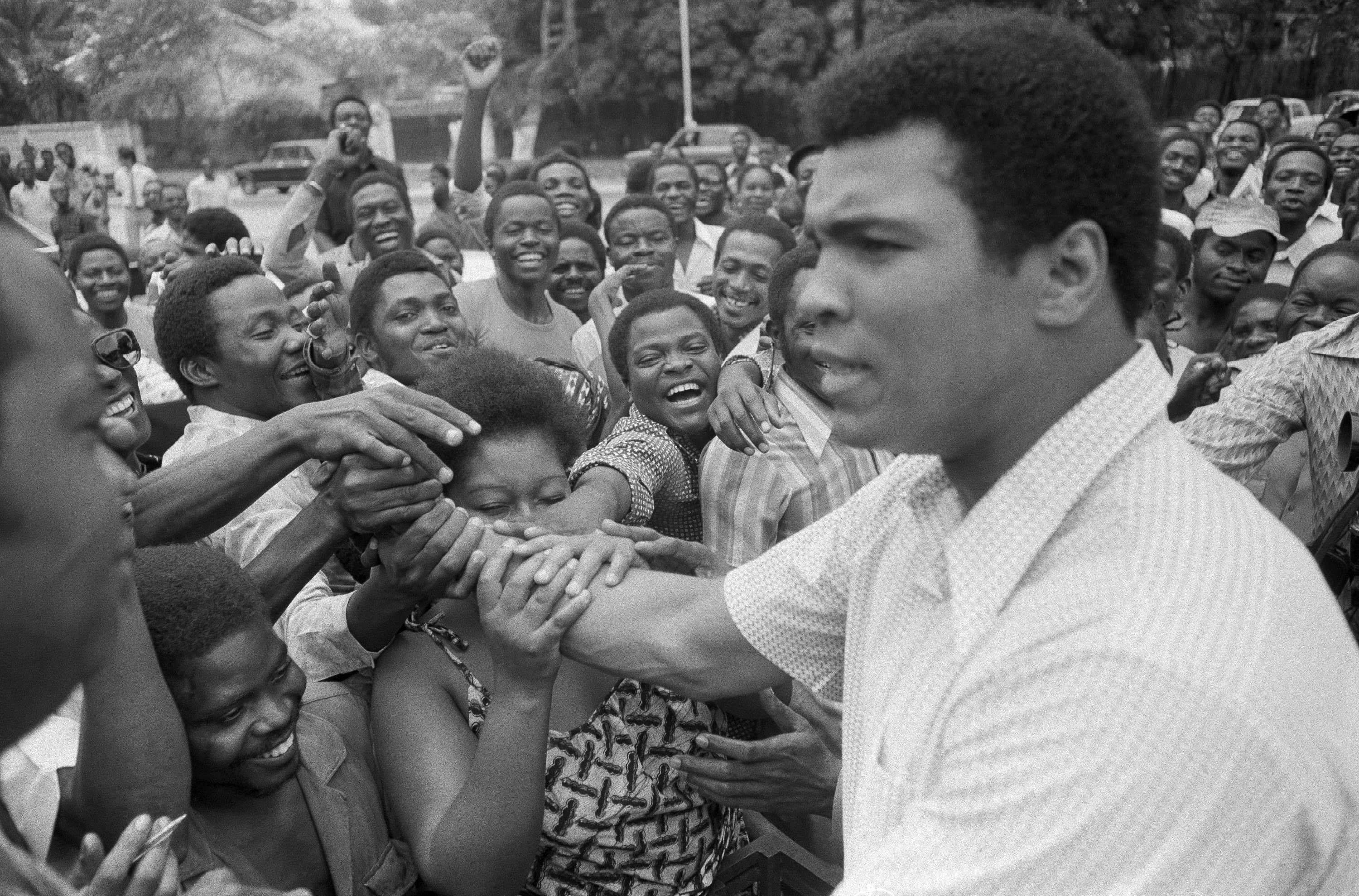 Muhammad Ali is greeted in downtown Kinshasa, Zaire, on Sept. 17, 1974. Ali was in Zaire to fight George Foreman. Ali, the magnificent heavyweight champion whose fast fists and irrepressible personality transcended sports and captivated the world, died on Friday, June 3, 2016. He was 74.