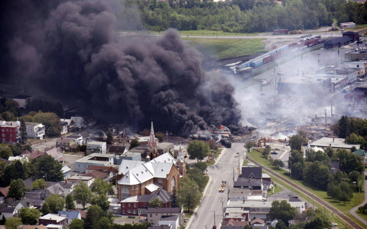 Smoke rises from burning railway cars July 6, 2013, after a derailment in downtown Lac Mégantic, Quebec, Canada.  An insurance expert said that damage estimates for that disaster are at about $3 billion, and that the railroad company involved has filed for bankruptcy because it didn&#039;t have enough insurance to pay the claims.