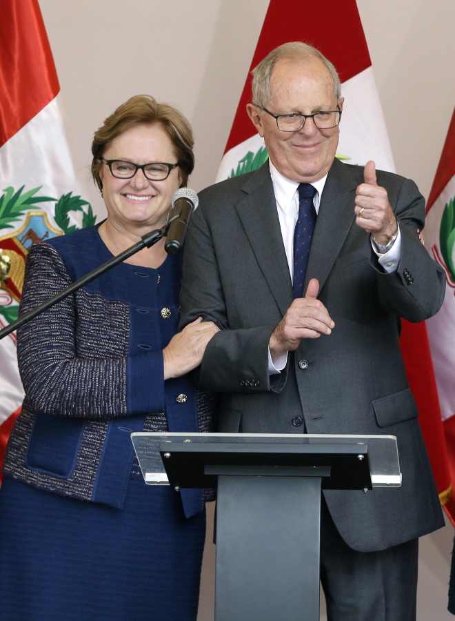 Pedro Pablo Kuczynski, accompanied by his wife, Nancy Lange, gives a thumbs-up sign Thursday at a news conference in Lima, Peru. He was declared the winner of the country's closest presidential contest in decades.