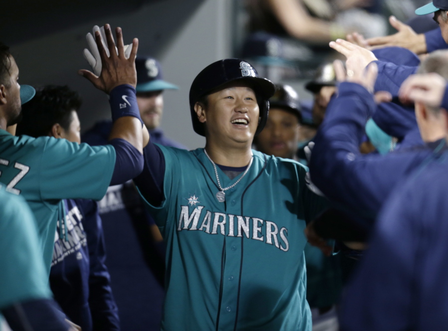 Seattle Mariners&#039; Dae-Ho Lee celebrates in the dugout after hitting a three-run home run off Texas Rangers&#039; Derek Holland during fourth inning of a baseball game Friday, June 10, 2016, in Seattle. This is his second home run of the night.