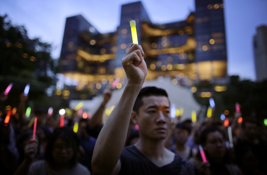 People raise glow sticks as open flames are banned in Singapore parks as they gathered for a vigil in remembrance of the Orlando shooting victims on Tuesday in Singapore. A tragedy half a world away has created an unlikely opening for a repressed community in Singapore. The mass shooting at a gay club in Orlando, Florida, has galvanized LGBT people in Singapore, where a vigil was held Tuesday to express solidarity with the victims.