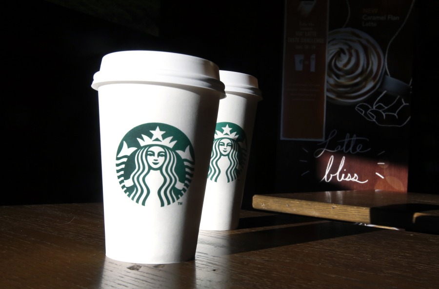 Friday, Jan. 17, 2014, file photo, Starbucks cups are shown mugs in a cafe in North Andover, Mass. A federal judge in San Francisco ruled on Friday, June 17, 2016, that a lawsuit claiming the Seattle-based coffee chain under fills its lattes can move forward.