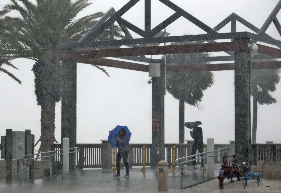 Beach goers get caught in a sudden downpour when a band associated from Tropical Storm Colin came ashore at Clearwater Beach on Monday in Clearwater, Fla. A large portion of Florida&#039;s western and Panhandle coast was already under a tropical storm warning when the National Hurricane Center announced that a swift-moving depression had become a named storm.