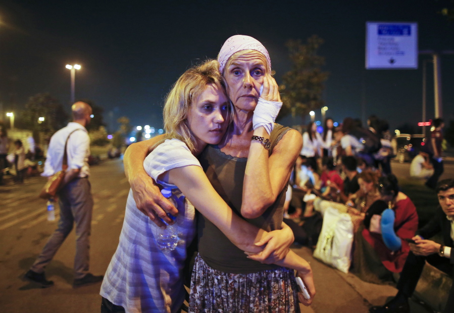 Passengers embrace as they wait outside Istanbul&#039;s Ataturk airport early today following their evacuation after an explosion.