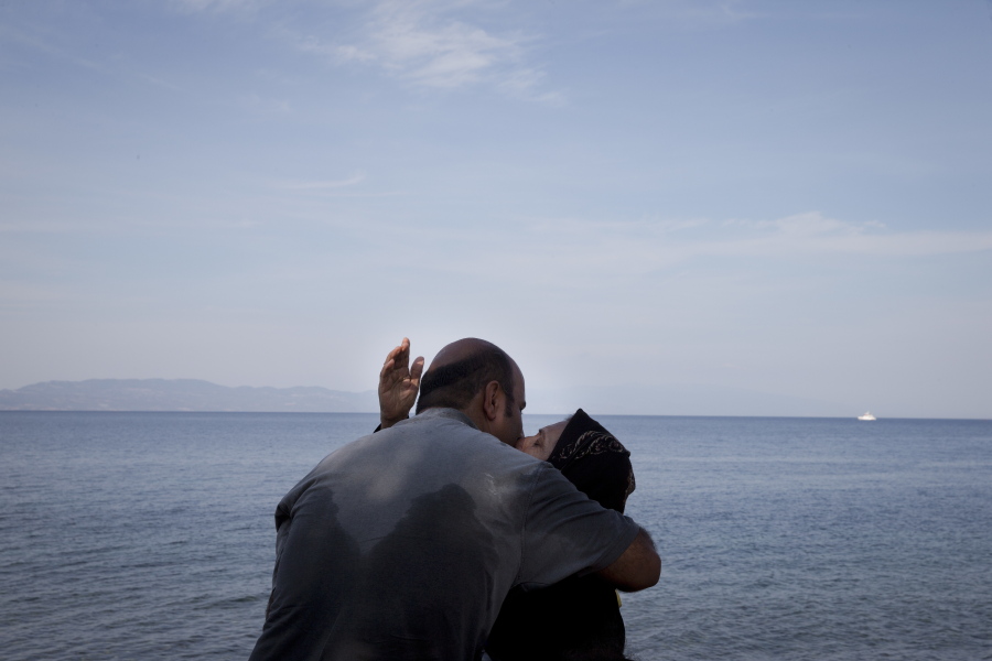 A woman and a man kiss as they arrive with others migrants from Turkey to Lesbos island, Greece, on a dinghy.