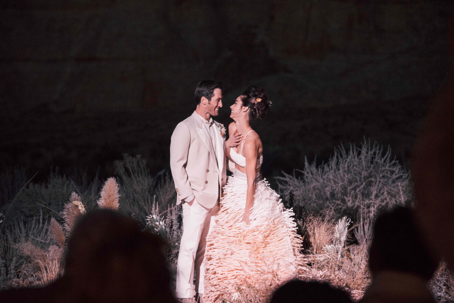 Bride Andi Potamkin wed Jordan Blackmore in an outdoor ceremony at the Canyon Point, Utah, resort Amangiri. The bride wore a custom skirt and bra top designed by Maurizio Galante.