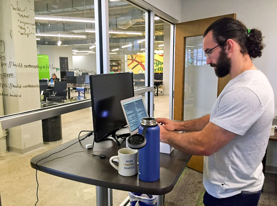 Nick Tate of ContainerShip, a cloud computing company in Pittsburgh, stands about 50 percent of the day. In addition to stretching and working out, he stands at his desk about half of the day to mitigate back pain.